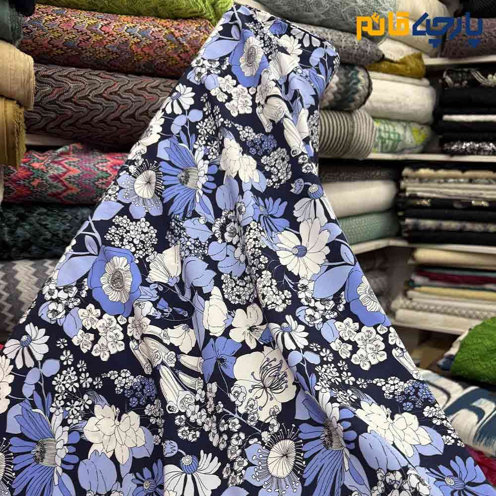 پارچه لینن طرحدار ریکو نخ ایتالیایی گلدار زمینه سرمه ای گل آبی سفید عرض 150 کد 12138