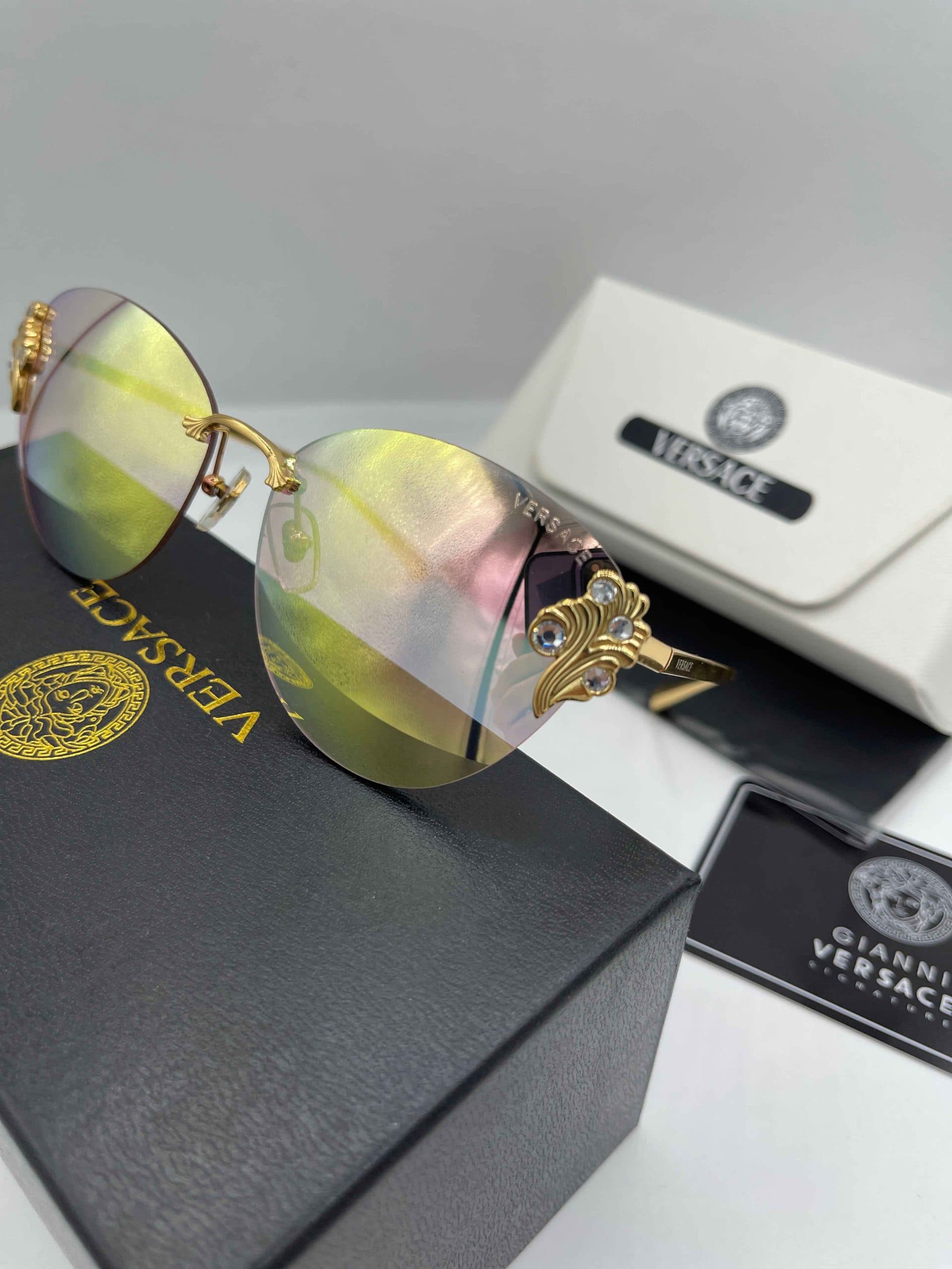 عینک آفتابی زنانه ورساچه (Versace) مدل بدون فریم با تزئینات کریستالی و جزئیات طلایی/نقره‌ای