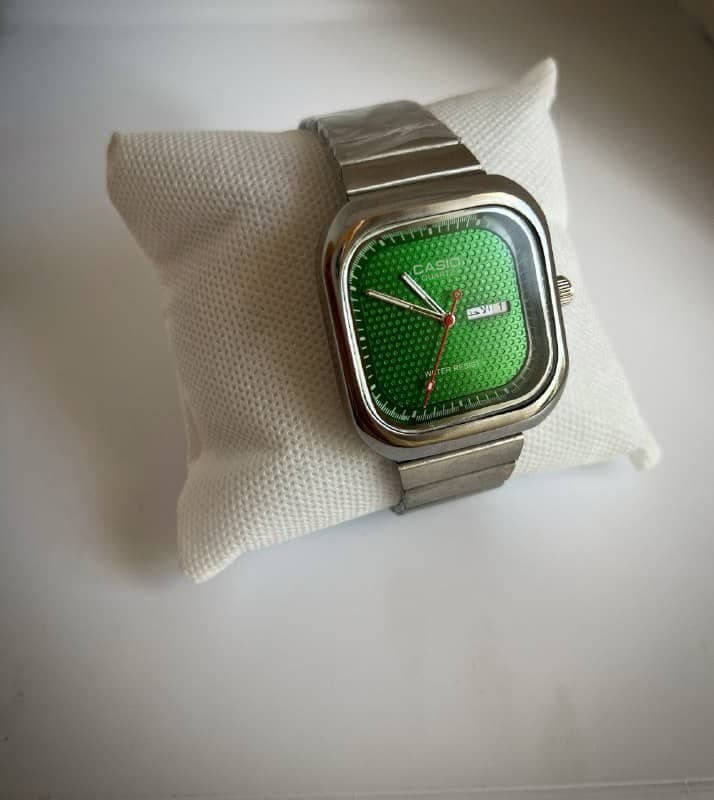 ساعت مچی کلاسیک کاسیو (Casio) – صفحه مربع/بالشی سبز و بند فلزی (نمایشگر عربی) — تصویر ۳