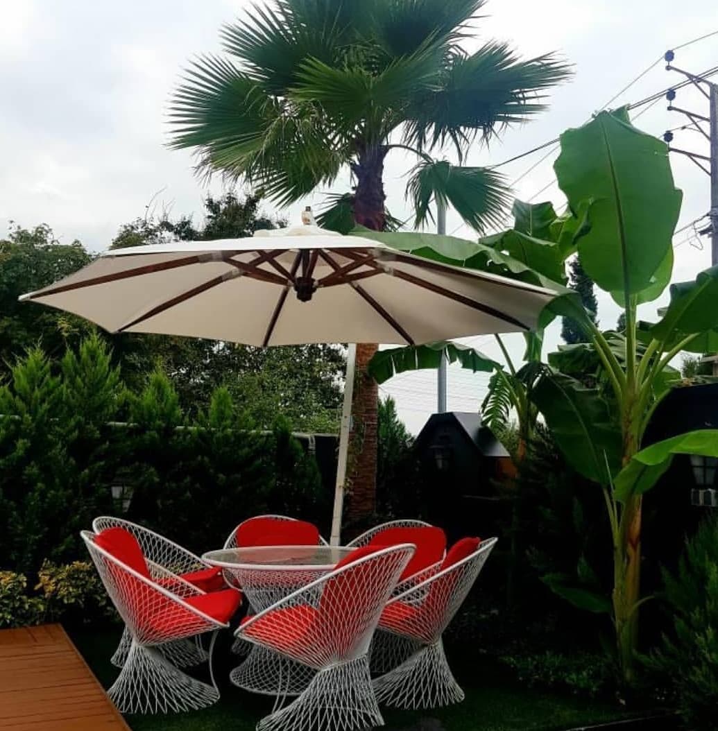 چتر پایه کنار مبلمان باغی — تصویر ۳