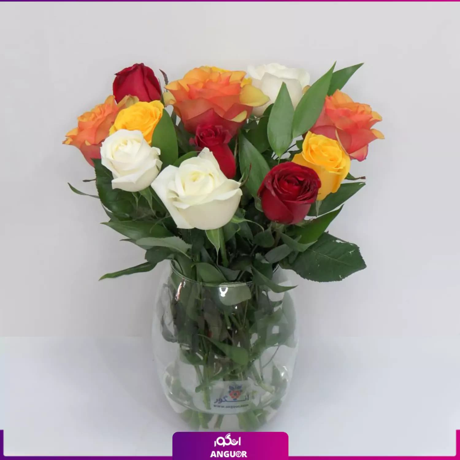 دسته گل رزهای رنگی 12 شاخه با گلدان شیشه‌ای