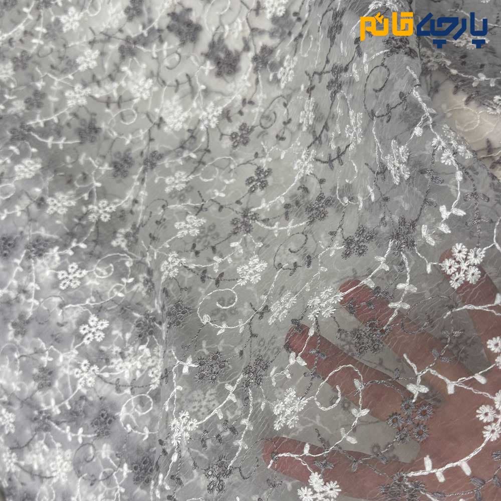 پارچه مجلسی تورکتان طرح گل متوسط و شاخه رنگ طوسی روشن و سفید زمینه اورگاندی کد۷۶۱۳ — تصویر ۲
