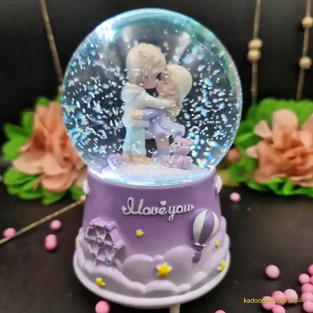 گوی شیشه ای بزرگ موزیکال پمپی برفی با شش طیف نوری طرح دختر و پسر I Love You رنگ یاسی