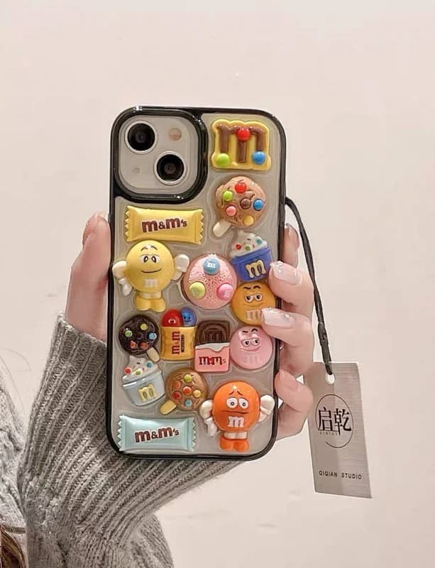 قاب استیکری عروسکی برجسته M&M گوشی آیفون 14 پرو — تصویر ۴