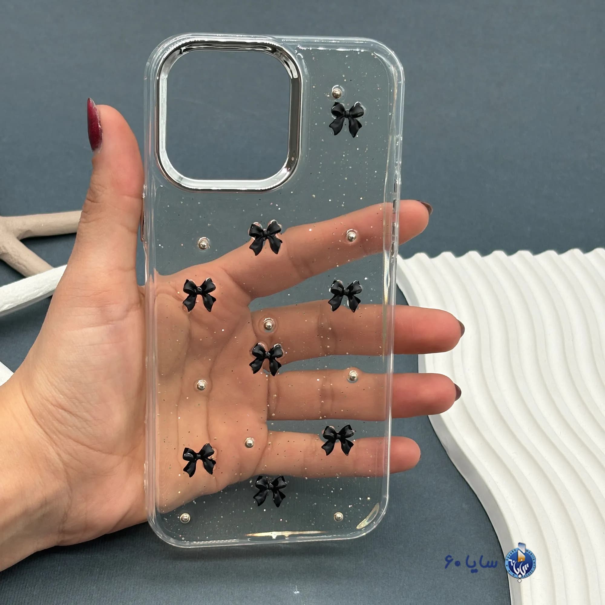 قاب موبایل IPHONE 16 PROMAX رزینی اکلیلی طلایی مدل پاپیون مشکی