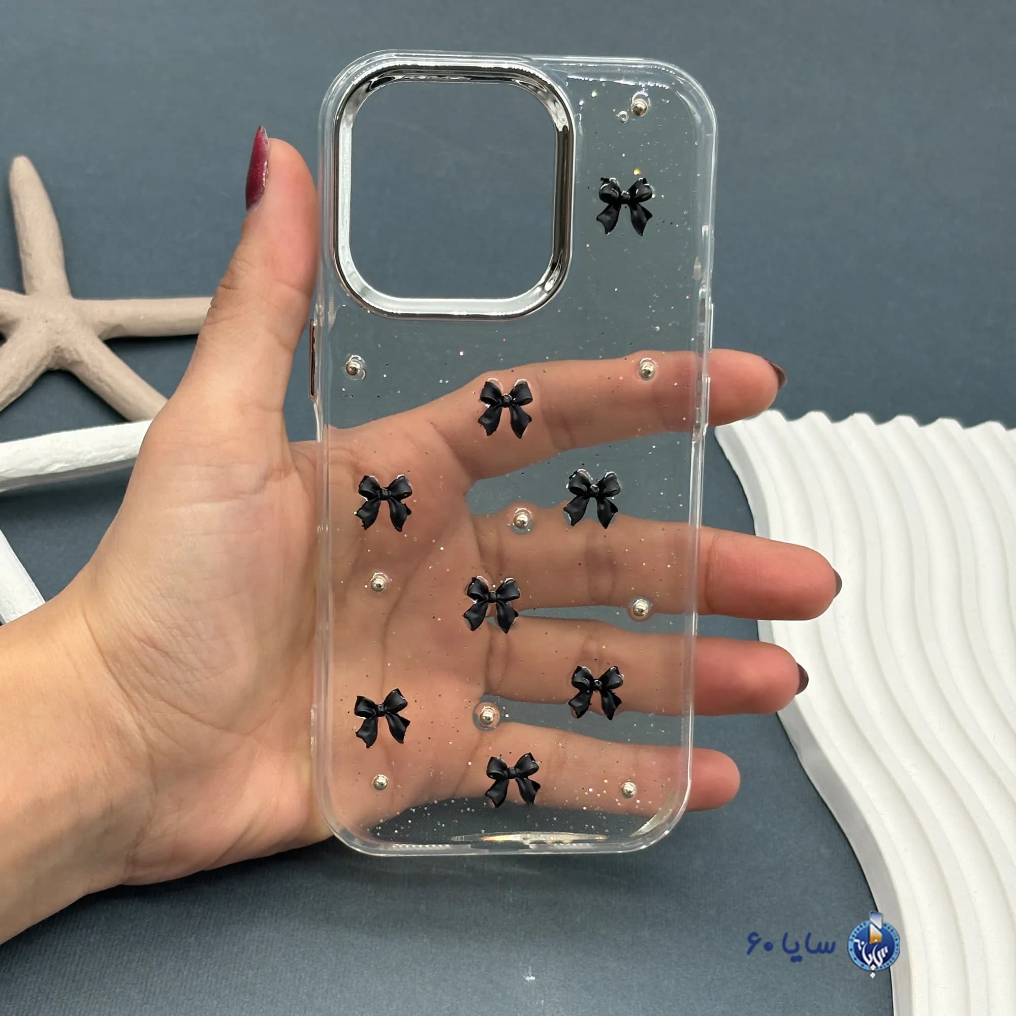 قاب موبایل IPHONE 16 PRO رزینی اکلیلی طلایی مدل پاپیون مشکی
