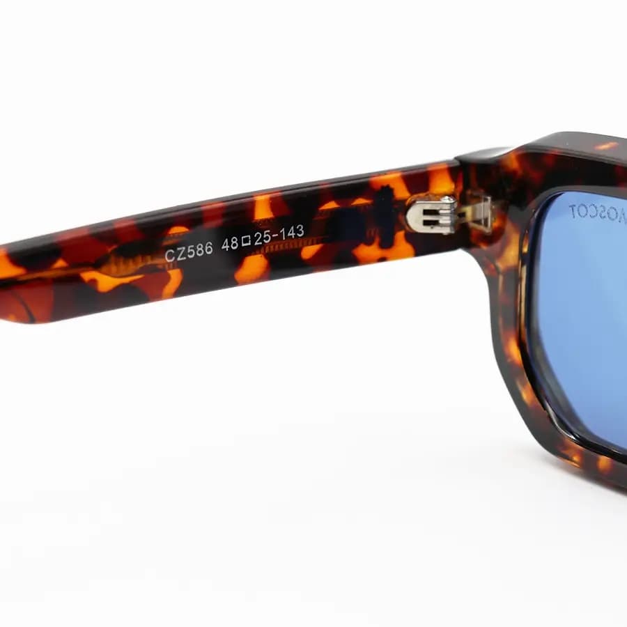 عینک آفتابی MOSCOT با فریم رنگ هاوانا براق، مستطیلی شکل، دسته سیم‌دار و لنز آبی تیره مدل CZ586 — تصویر ۶