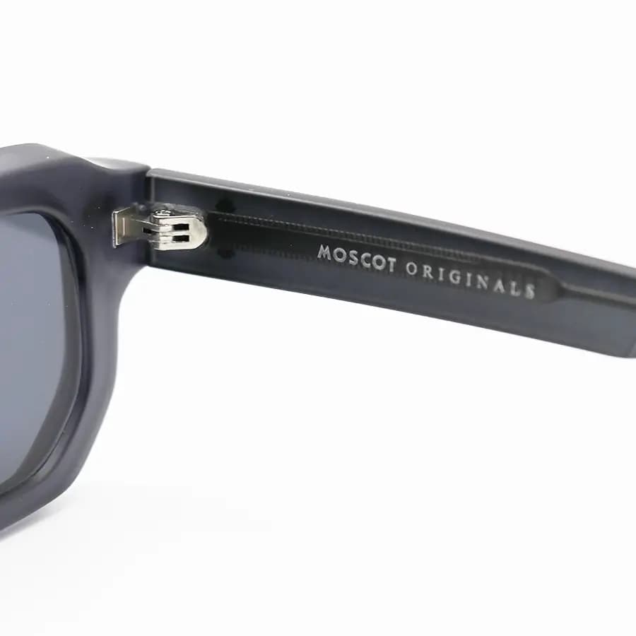 عینک آفتابی MOSCOT با فریم رنگ هاوانا براق، مستطیلی شکل، دسته سیم‌دار و لنز آبی تیره مدل CZ586 — تصویر ۱۱