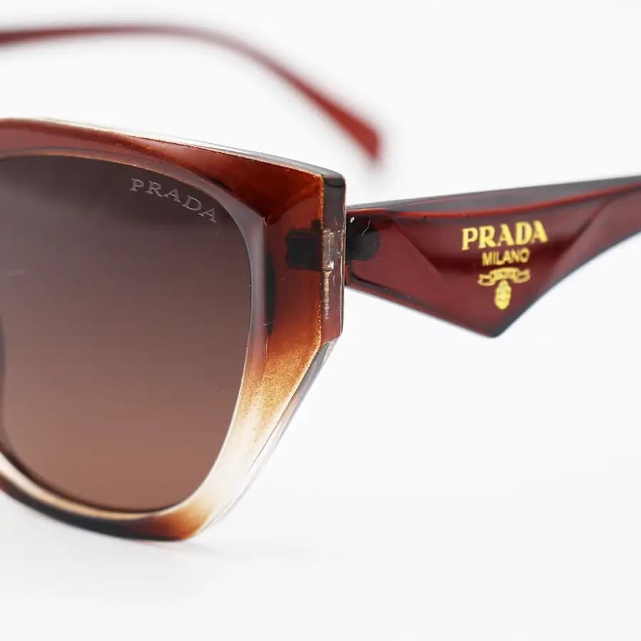 عینک آفتابی زنانه Prada با فریم قهوه‌ای براق، شکل چشم گربه‌ای و لنز قهوه‌ای تیره و هایلایت مدل 2001 — تصویر ۶