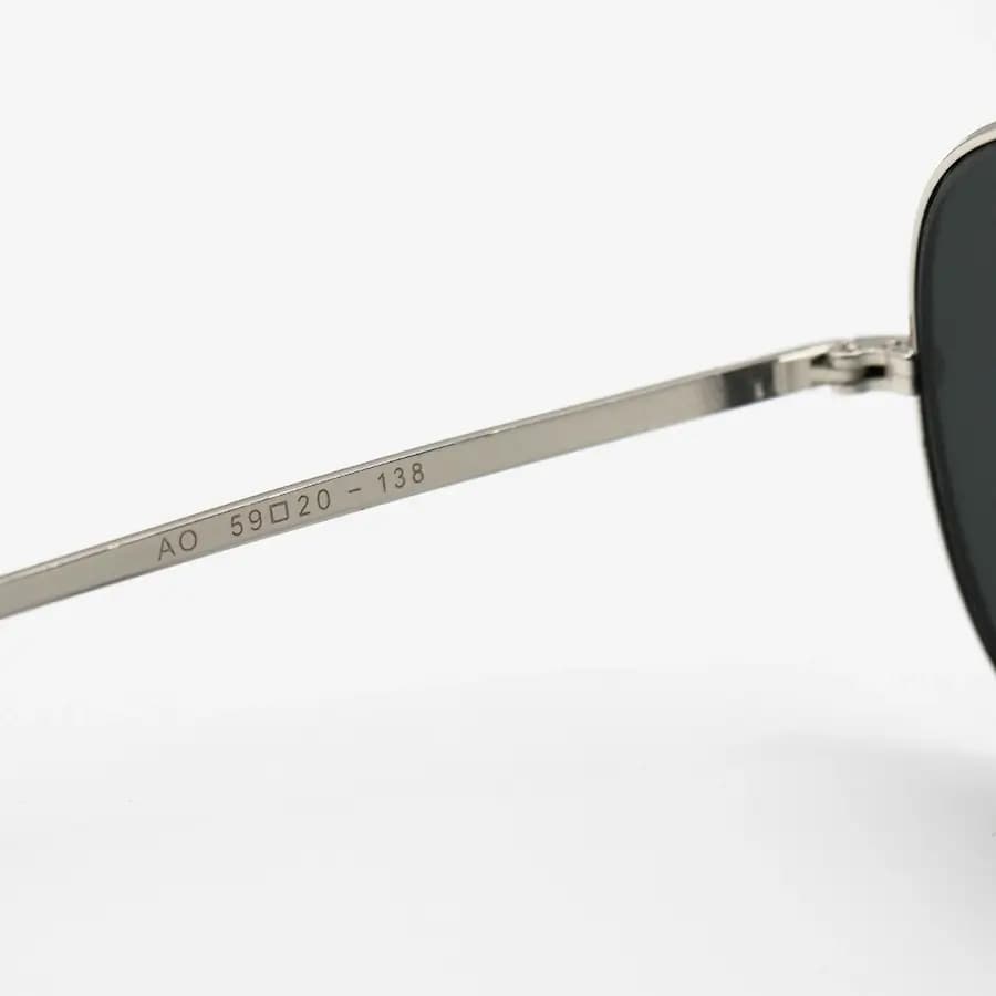 عینک آفتابی American Optical با فریم خلبانی، رنگ نقره‌ای براق، عدسی جنس سنگ (شیشه) و دودی تیره مدل AO-1004 — تصویر ۸