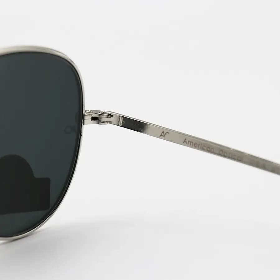عینک آفتابی American Optical با فریم خلبانی، رنگ نقره‌ای براق، عدسی جنس سنگ (شیشه) و دودی تیره مدل AO-1004 — تصویر ۵