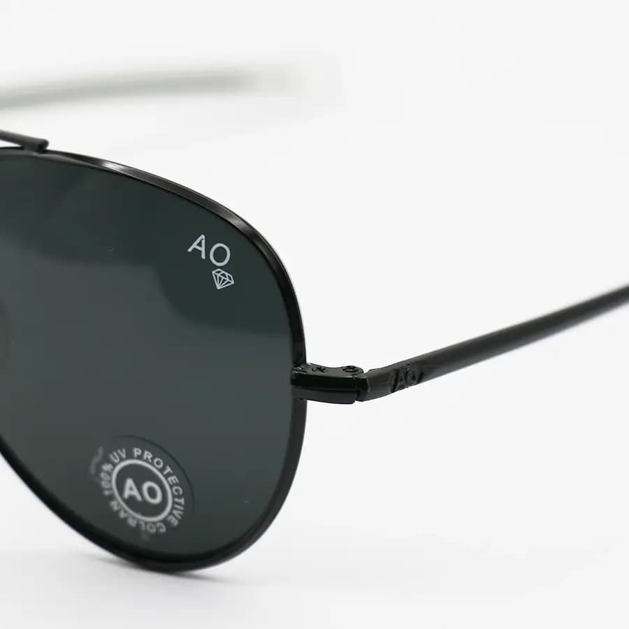 عینک آفتابی American Optical با فریم خلبانی، رنگ مشکی براق، عدسی جنس سنگ (شیشه) و دودی تیره مدل AO-1004 — تصویر ۶