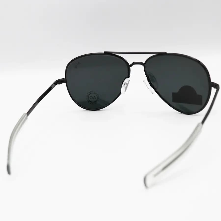 عینک آفتابی American Optical با فریم خلبانی، رنگ مشکی براق، عدسی جنس سنگ (شیشه) و دودی تیره مدل AO-1004 — تصویر ۴