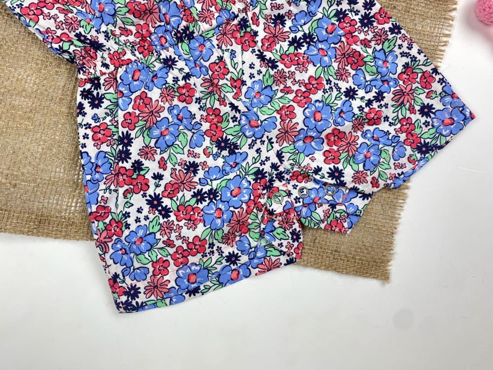 رامپر نوزادی دخترانه آستین تاپ طرح گل گلی آستین چین داره حلقه ای جلو دکمه ای سفید رنگ – 12 ماه — تصویر ۲