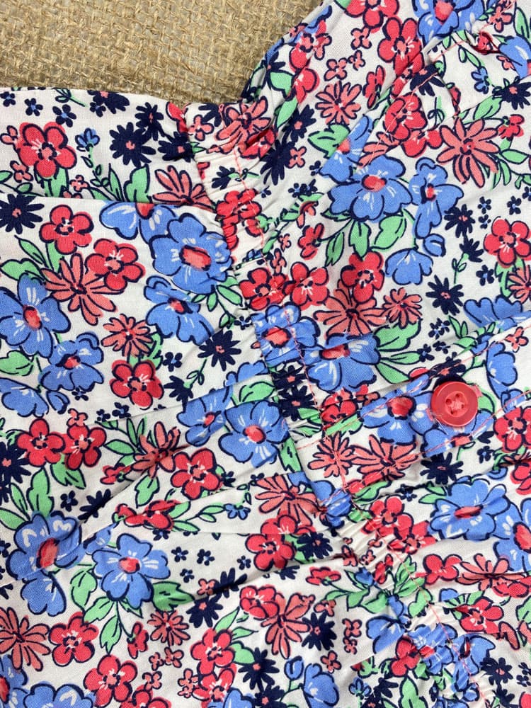 رامپر نوزادی دخترانه آستین تاپ طرح گل گلی آستین چین داره حلقه ای جلو دکمه ای سفید رنگ – 12 ماه — تصویر ۳