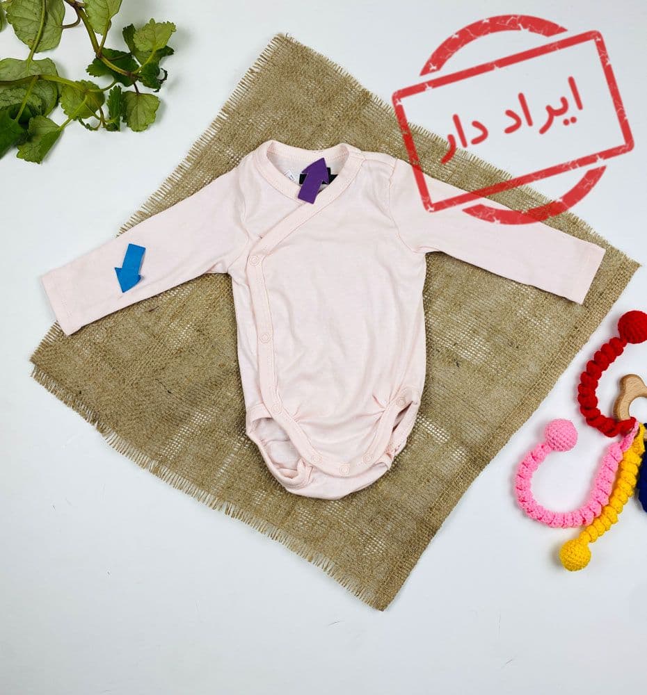ایراد دار _ بادی نوزادی آستین بلند طرح ساده یقه هفت به حالت کج دکمه دارد صورتی کمرنگ – 1 تا 2 ماه