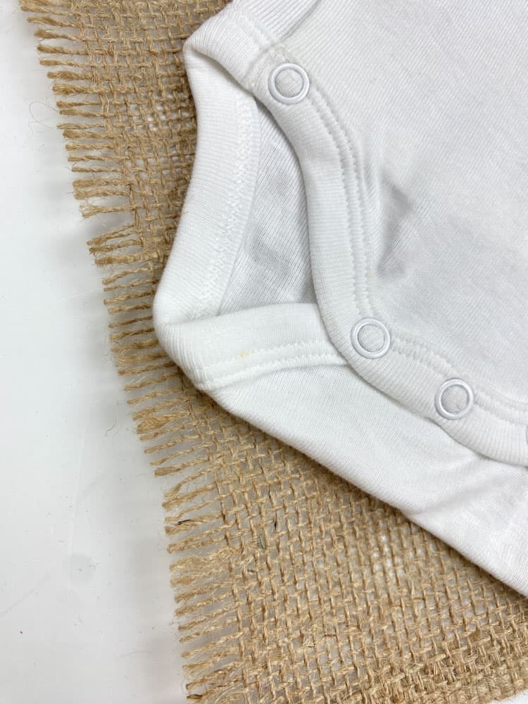 ایراد دار _ بادی نوزادی آستین کوتاه برند Obaibi طرح خرس کوچولو یقه هفت مدل کج دکمه ای سفید رنگ – 3 ماه — تصویر ۳