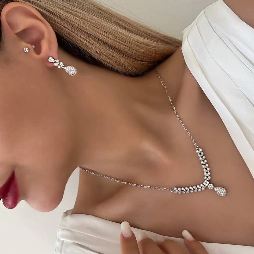 ست گردنبند و گوشواره زنانه طرح برگ شبدر با آویز قطره نگین زیرکن رنگ نقره ای مناسب روزمره و مهمانی جنس استیل ضد حساسیت و رنگ ثابت کد zmc