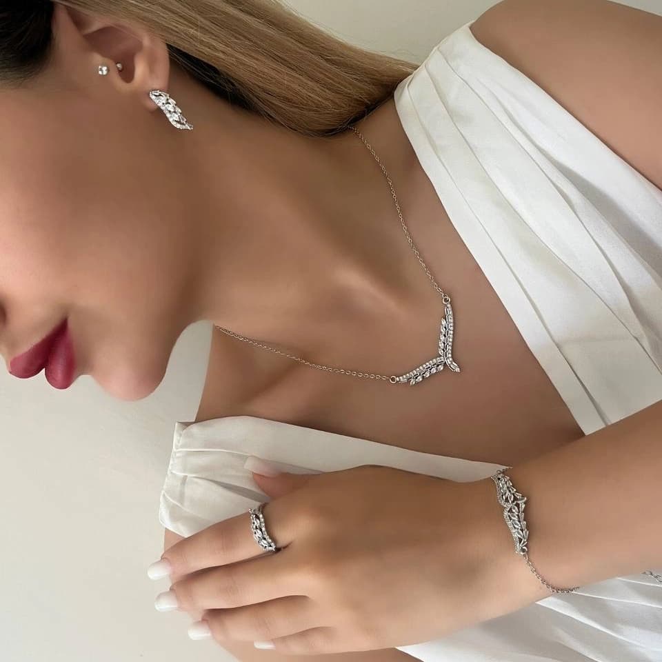 ست گردنبند و گوشواره زنانه طرح بال جواهری نگین زیرکن رنگ نقره ای مناسب روزمره و مهمانی جنس استیل ضد حساسیت و رنگ ثابت کد zmc