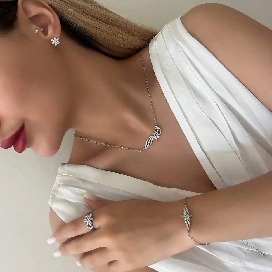 ست گردنبند و گوشواره جواهری زنانه طرح گل و موج نگین زیرکن رنگ نقره ای مناسب روزمره و مهمانی جنس استیل ضد حساسیت و رنگ ثابت کد zmc