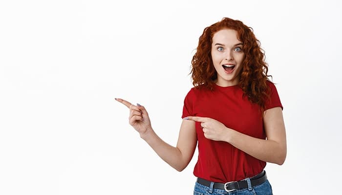 تصویر زمینه سفید دختر جوان متعجب و اشاره کردن به چپ