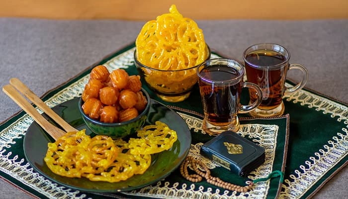 تصویر پس زمینه سجاده و سفره افطار با زولبیا و بامیه