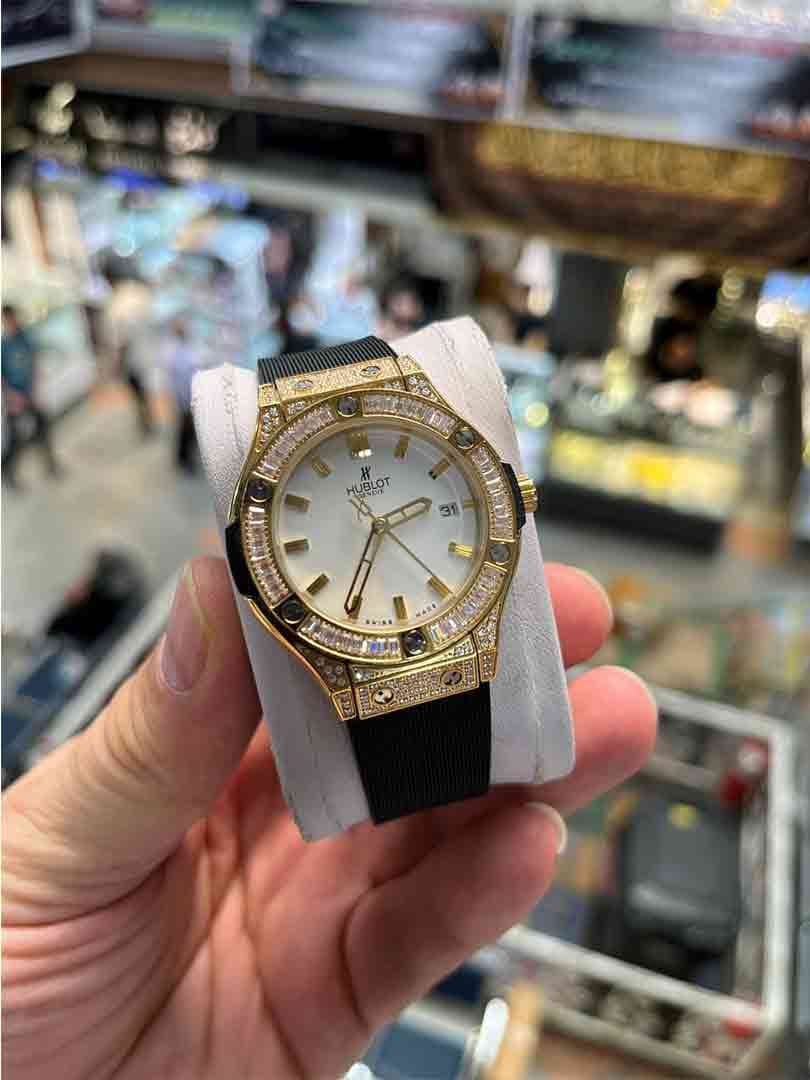 ساعت مچی زنانه هابلوت دورفول نگین بندمشکی قاب طلایی صفحه سفید مدل Hublot Diamonds
