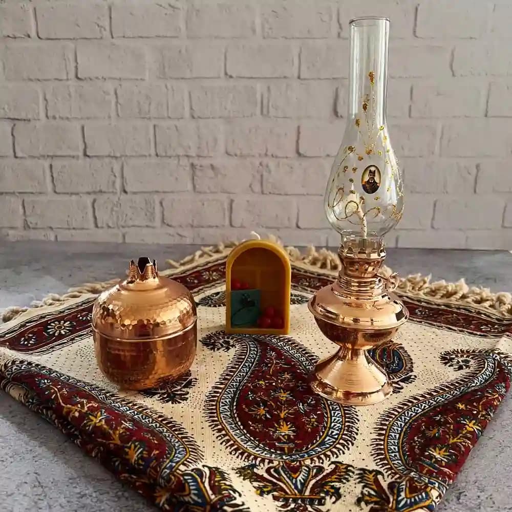 پک راز شب بلند یلدا شامل رومیزی قلمکار، چراغ مسی، شمع و قندان انار — تصویر ۴