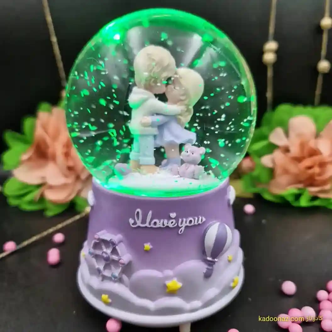 گوی شیشه ای بزرگ موزیکال پمپی برفی با شش طیف نوری طرح دختر و پسر I Love You رنگ یاسی — تصویر ۳