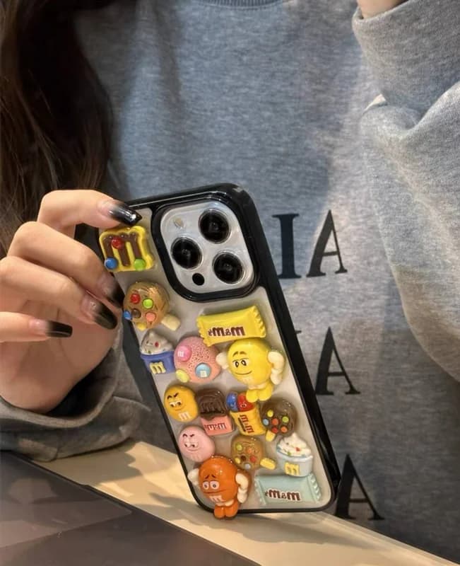 قاب استیکری عروسکی برجسته M&M گوشی آیفون 13 پرومکس — تصویر ۵