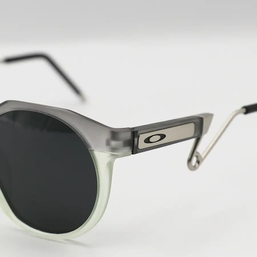 عینک ورزشی OAKLEY با فریم گرد، رنگ طوسی و سبز مات، دسته سنجاقی و لنز دودی تیره و پلاریزه مدل OO9279 — تصویر ۵