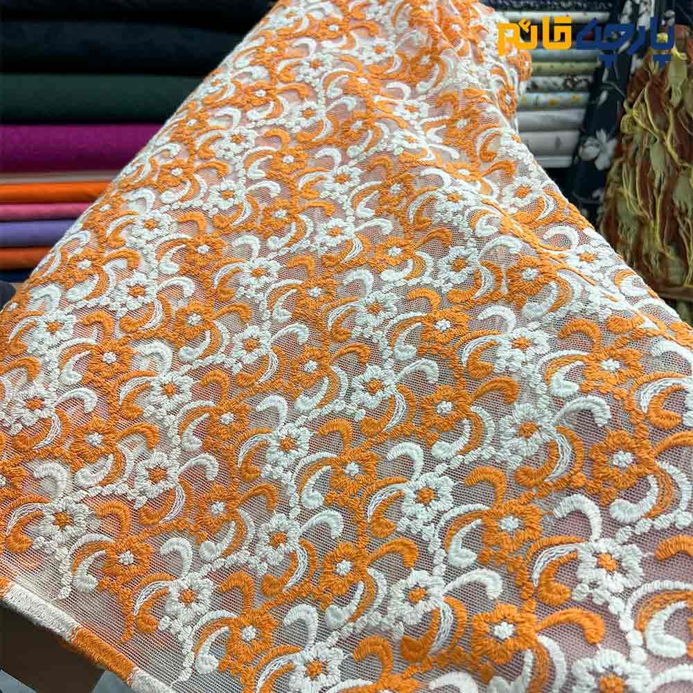 پارچه مجلسی تورکتان زمینه تور ظریف برجسته رنگ نارنجی کرم عرض ۱۴۵کد5984
