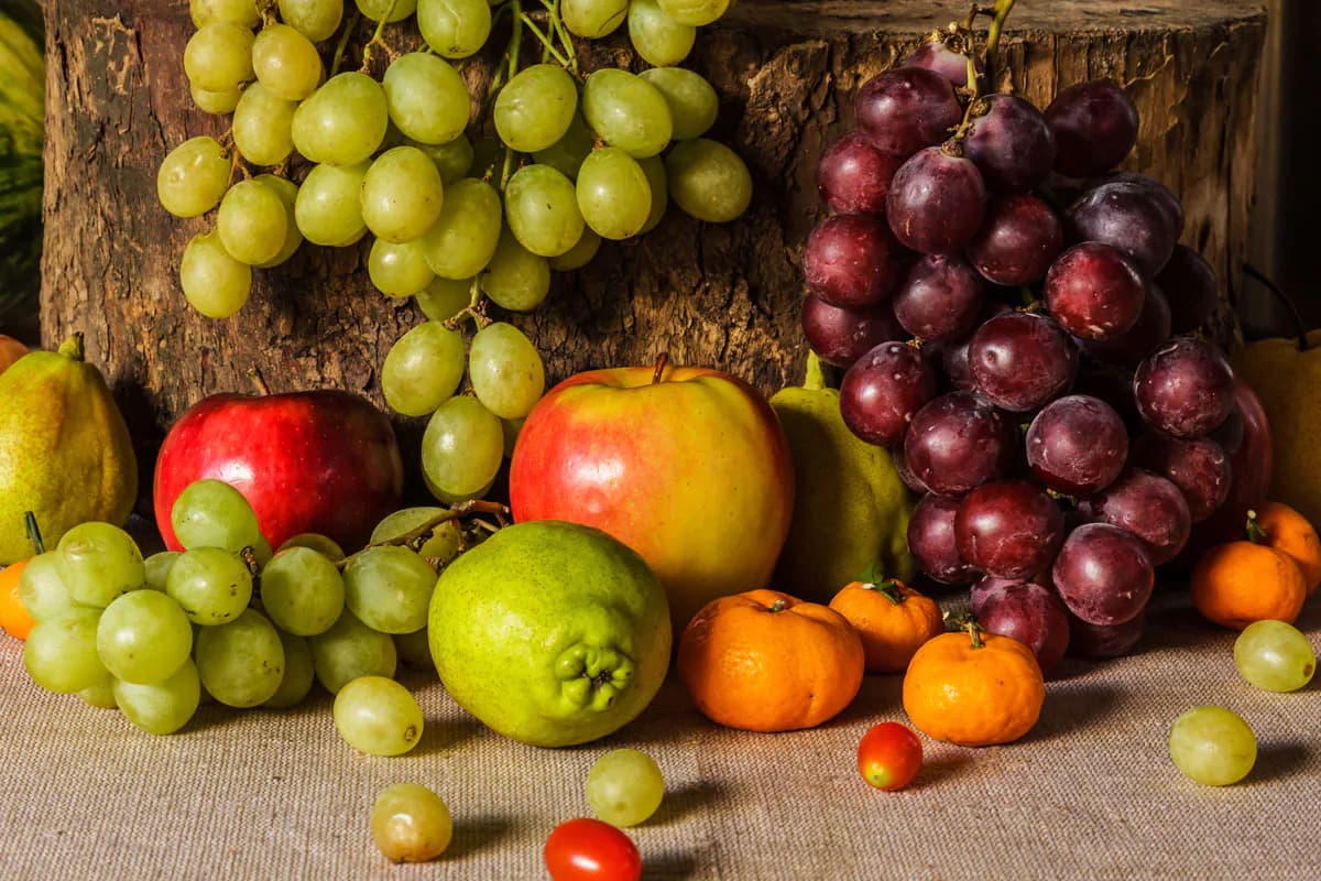 تصویر استوک انگور و میوهها روی تنه درخت