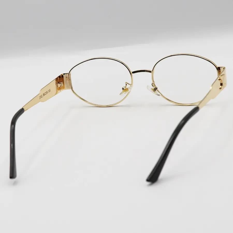 فریم عینک ترند سلین (CELINE) با فریم بیضی شکل، رنگ طلایی و لنز بیرنگ و بلوکات مدل JD2380 — تصویر ۴