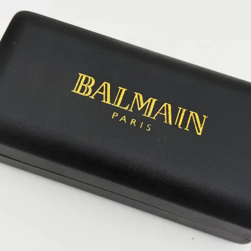 پک و جعبه عینک اورجینال بالمین Balmain پاریس هارد چرم مشکی طلایی — تصویر ۷