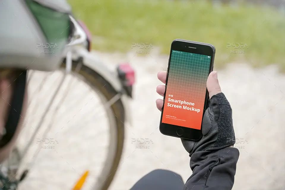 موکاپ موبایل آیفون SE در دست کنار دوچرخه و پارک iPhone SE Mockup — تصویر ۳